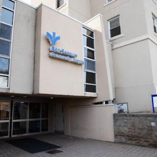 The entrance of a modern building featuring prominent signage.
