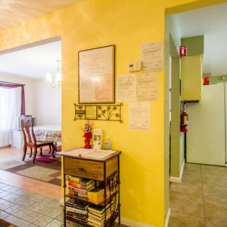 A cozy interior showcasing a yellow wall with a view into the dining and kitchen areas.