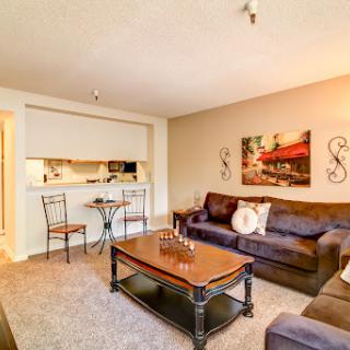 A cozy living room featuring a comfortable sofa, modern coffee table, and dining area seamlessly integrated.