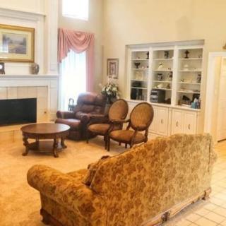 A cozy traditional living room with elegant furniture and a fireplace.