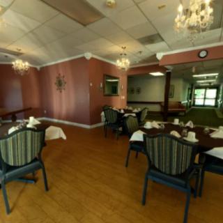An elegant dining room with neatly set tables and chandeliers.