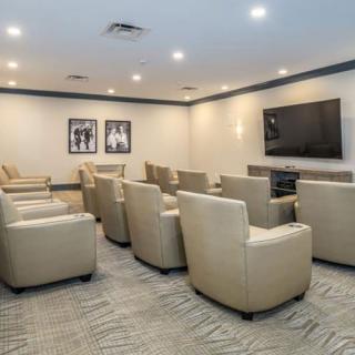 A modern theater room with comfortable seating and a large television screen.