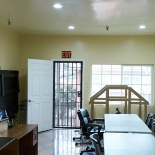 A well-lit office space with desks, chairs, and computer monitors.