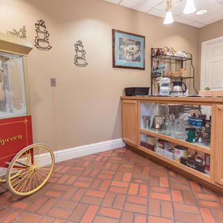 A cozy reception area featuring a vintage popcorn machine and a display case with various items.