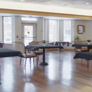 A spacious dining area featuring elegant tables and chairs, illuminated by natural light.
