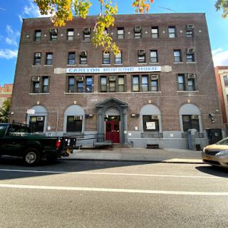 A classic brick building in an urban setting, showcasing architectural details and a welcoming entrance.