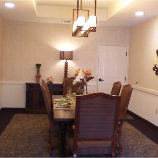 A well-appointed dining room featuring a wooden table and matching chairs, accented by elegant lighting and decor.