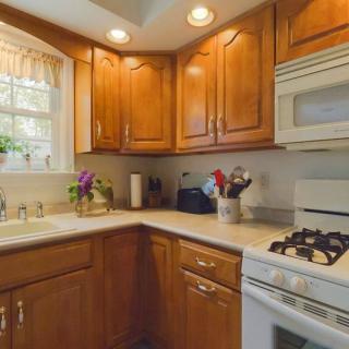 A cozy kitchen with wooden cabinets, a gas stove, and a microwave.