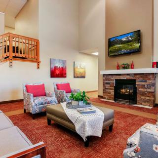 A modern living room with a cozy fireplace, stylish furniture, and decorative artwork.