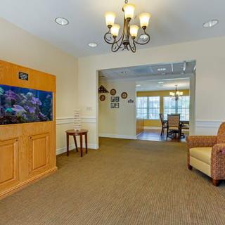 A cozy living room featuring an aquarium, chandelier, and comfortable seating.