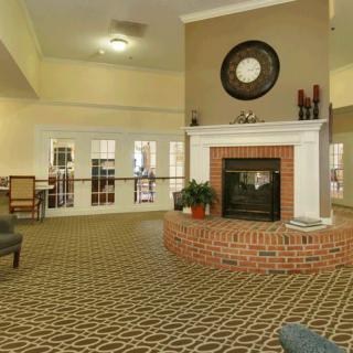 A cozy living room featuring a central fireplace with surrounding seating and elegant interior design.