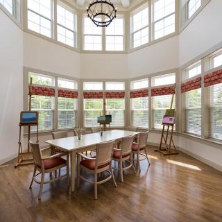 A bright dining room with large windows and elegant furnishings.