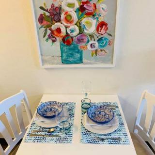 A cozy dining setup with colorful floral artwork and neatly arranged tableware.