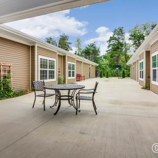 A spacious courtyard with outdoor furniture surrounded by buildings and trees.