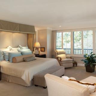 A luxurious bedroom with elegant furnishings and large windows.