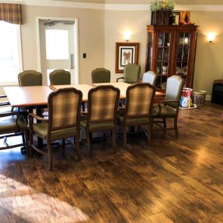 A well-furnished dining room with a wooden table, chairs, and a cabinet.