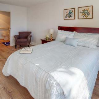 A cozy bedroom with a neatly made bed and warm decor.