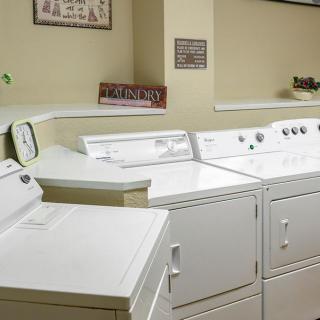 A clean and organized laundry room with several washing machines and dryers.