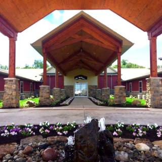 A symmetrical entrance of a building with stone pillars and flowering plants.
