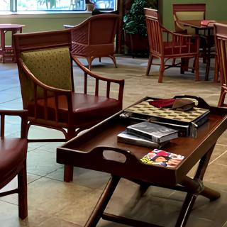 A cozy lounge area with wooden chairs and a table featuring magazines.