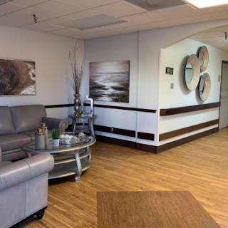 A cozy and modern waiting area with comfortable seating and decorative artwork on the walls.