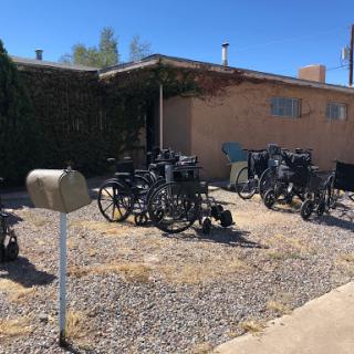 A residential area featuring a variety of vehicles parked on gravel.