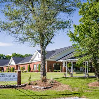 A view of a residential facility surrounded by greenery and a clear blue sky.