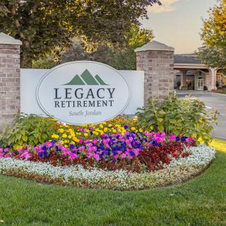 Entrance sign with colorful landscaping at a retirement community.