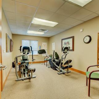 A small gym with exercise equipment and seating.