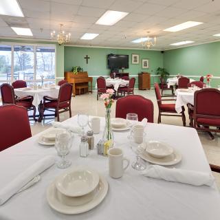 An elegantly set dining room with tables and chairs, ready for guests.