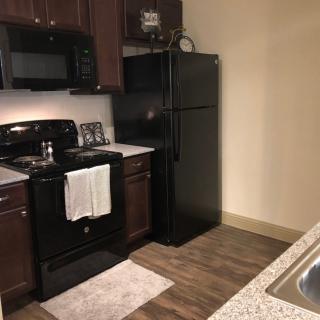 A modern kitchen with black appliances and wooden cabinets.