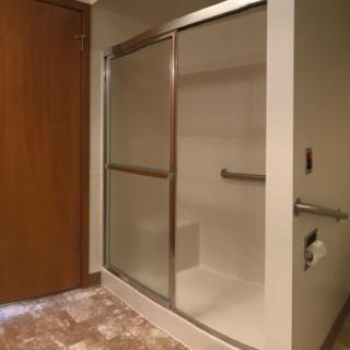 A modern bathroom with a glass-enclosed shower and tiled flooring.