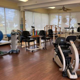 A physical therapy room equipped with various exercise machines and rehabilitation tools.