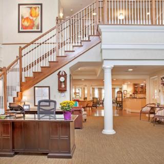 A welcoming office reception area with a prominent staircase and desk.