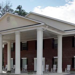 A brick building with a large porch and white columns.
