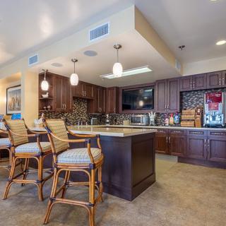 A modern kitchen with elegant wooden cabinetry and stylish bar seating.