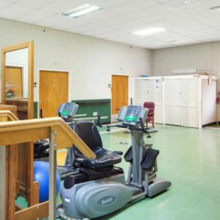 A rehabilitation room with various exercise equipment for physical therapy.