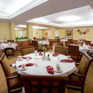 A well-decorated dining room with round tables set for a meal.