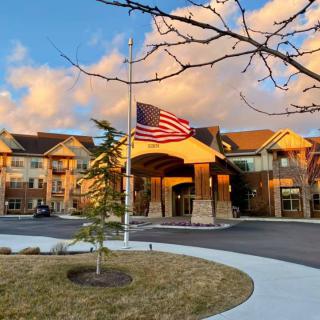 A picturesque view of a building with an American flag at sunset.