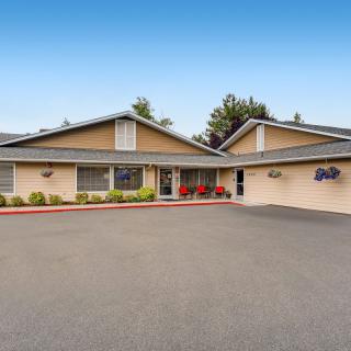 A suburban residential building with a spacious driveway and landscaped surroundings.