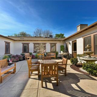 A cozy patio with wooden furniture and lush greenery on a sunny day.