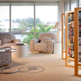 A cozy modern living room featuring comfortable seating and a stylish bookshelf, bathed in natural light.