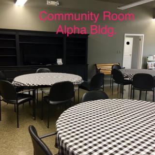A community room with checkered tablecloth-covered tables and chairs.