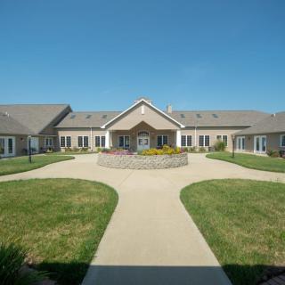 A large building with a courtyard and pathways under a clear blue sky.