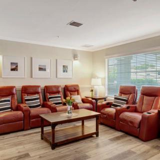 A cozy living room with red armchairs and a wooden coffee table.