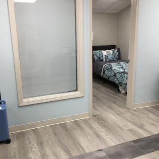 A view of a cozy bedroom with floral bedding, seen through a glass partition.