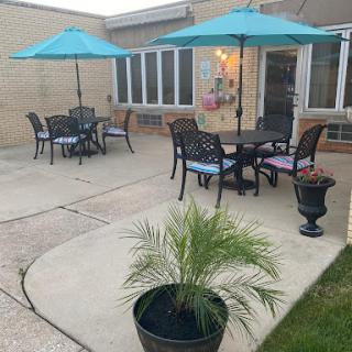 A cozy outdoor patio setup featuring tables, chairs, and vibrant umbrellas for shade.