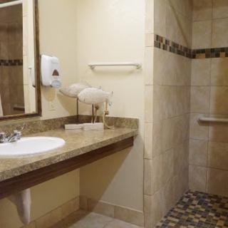 A well-designed bathroom featuring a sink, mirror, and shower area with elegant tile work.