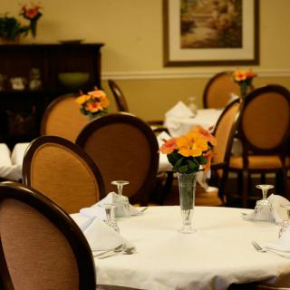 A cozy restaurant dining area with elegantly set tables and floral decorations.