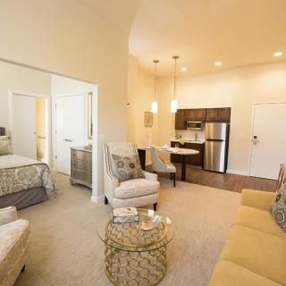 A cozy and modern open floor plan apartment with a living room, kitchen, and bedroom.